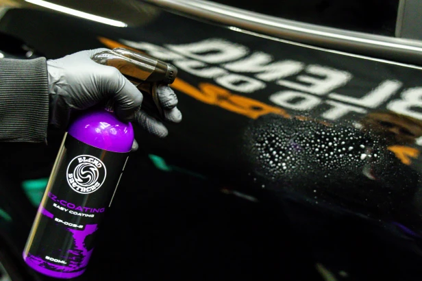 Prezentacja butelki EZ COATING 500ml podczas prac detailingowych przy samochodzie