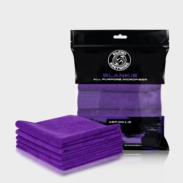 Profesjonalny packshot zestawu 5 fioletowych mikrofibr Blankie z opakowaniem zbiorczym na jasnoszarym tle.