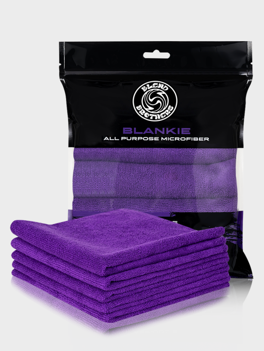Profesjonalny packshot zestawu 5 fioletowych mikrofibr Blankie z opakowaniem zbiorczym na jasnoszarym tle.