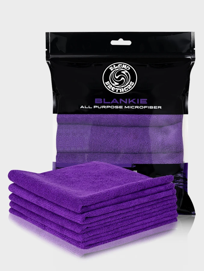 Profesjonalny packshot zestawu 5 fioletowych mikrofibr Blankie z opakowaniem zbiorczym na jasnoszarym tle.