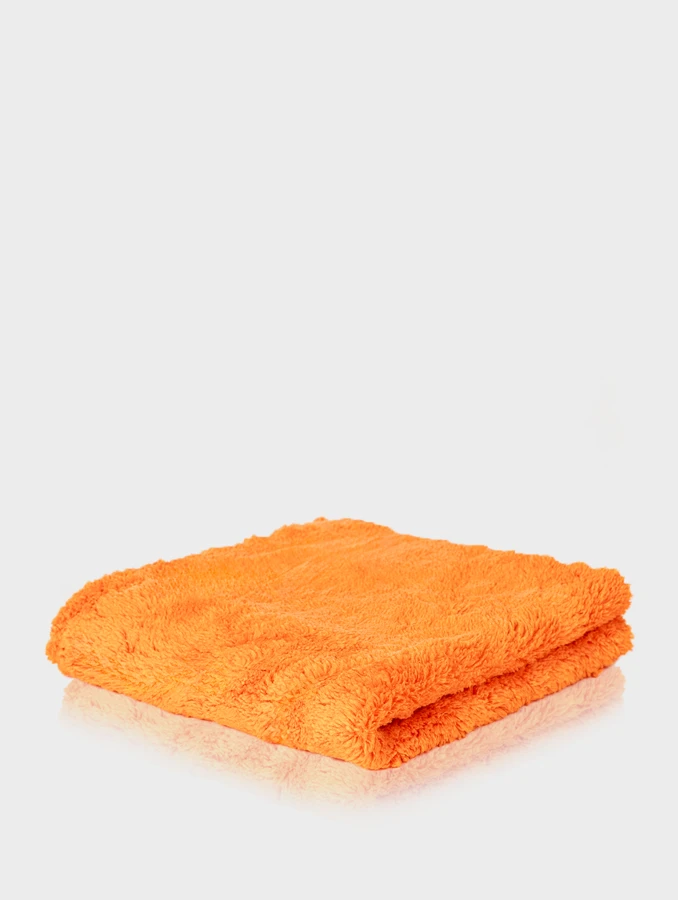 Puszysta pomarańczowa mikrofibra Blend Brothers Plushie 500GSM złożona w kwadrat na jasnym tle.
