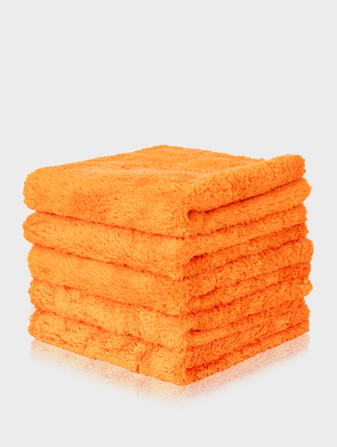 Wysoki stos pięciu puszystych pomarańczowych mikrofibr bezszwowych Plushie o gramaturze 500GSM.