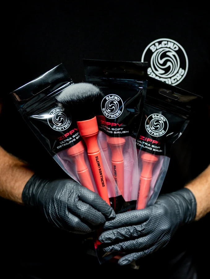 Front opakowania pędzelka Zippy z magentowym oznaczeniem serii i logo Blend Brothers. Pokazanie gamy produktów w dłoniach.