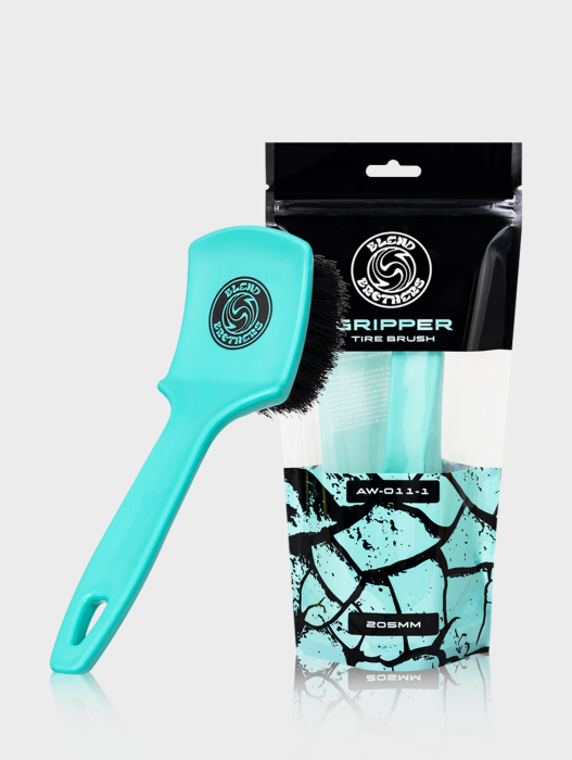 Szczotka do opon Gripper Tire Brush z turkusowym włosiem obok opakowania na jasnym tle.